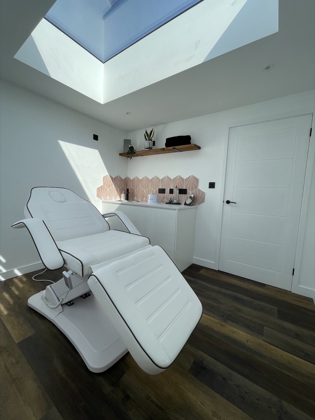 The treatment room at Cherish Beauty, with a white treatment bed beneath a skylight